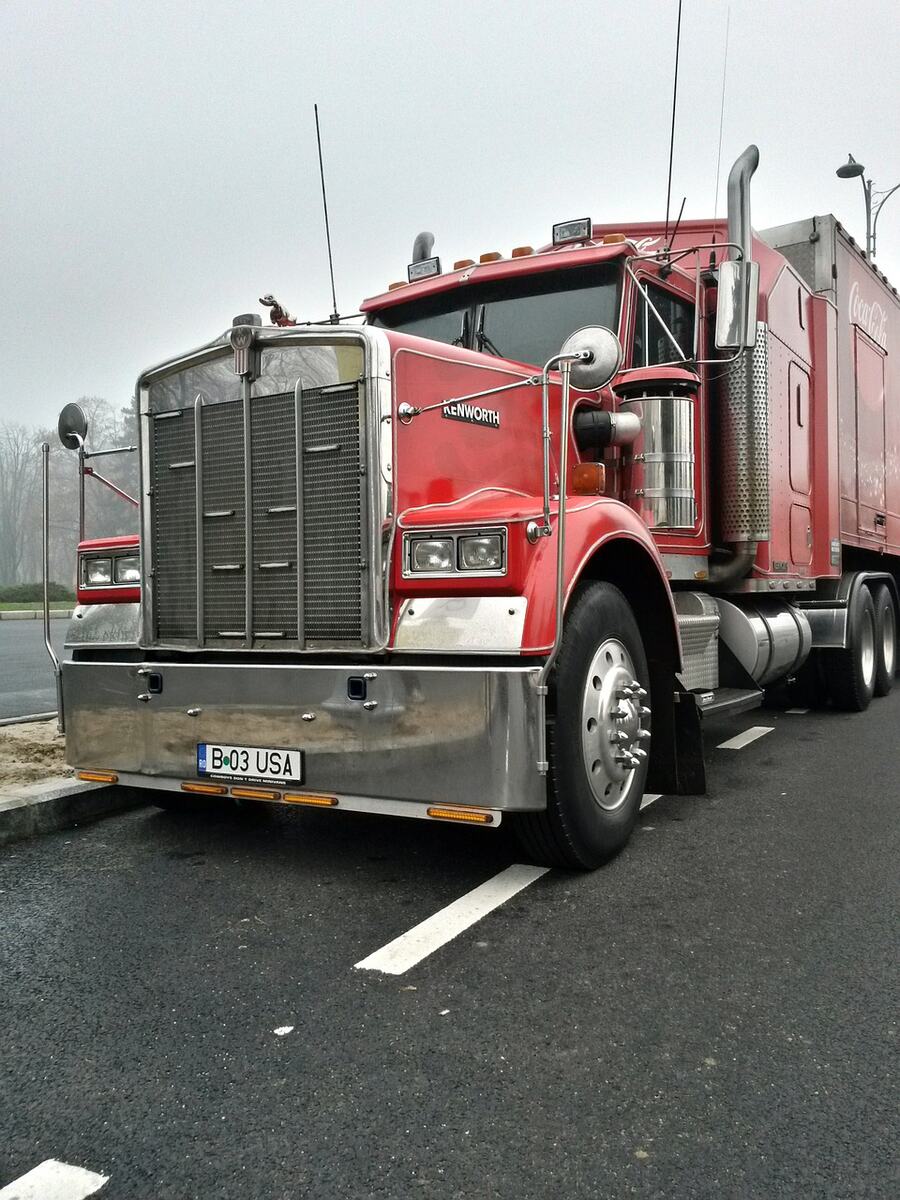 A red semi truck parked on a wet road